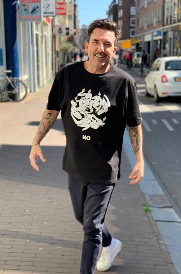 Martijn loopt lachend door een straat in Amsterdam
